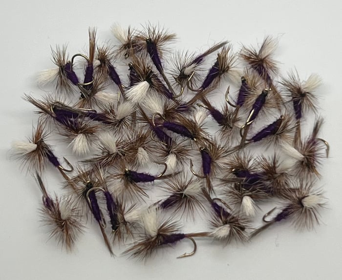 Fleeger's hand-tied parachute dries — a pile of purple-bodied parachutes with white posts, proof he ties across the board and not just one niche