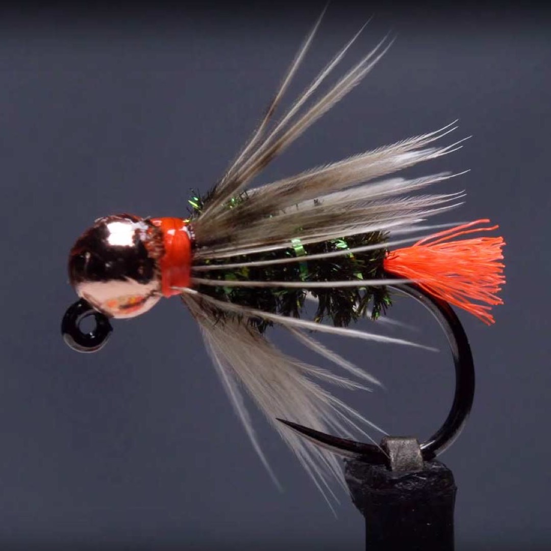 Olsen's Blowtorch jig nymph in the vise — copper tungsten bead, orange hot-collar and tag, green flash body