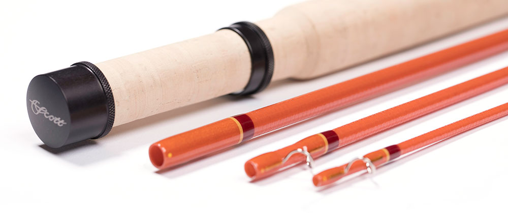 Scott F Series E-glass fly rod — cork grip and black anodized reel seat beside three amber fiberglass blank sections with red wraps and chrome snake guides (photo: Scott Fly Rod Company)