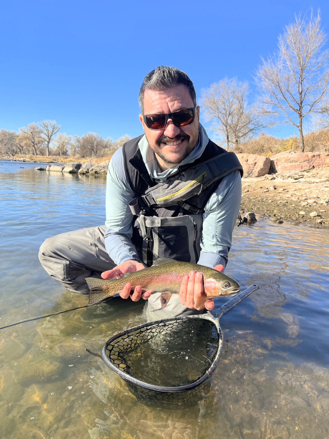 A rainbow brought to hand on a slow, clear tailwater flat — the water where leading the drift earns its keep