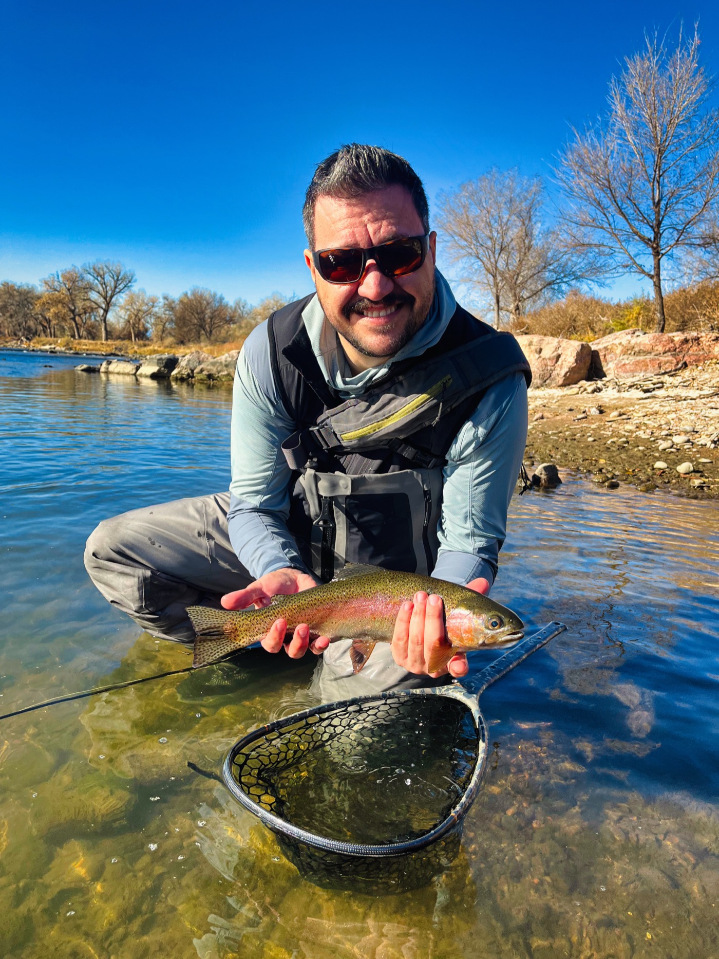 A South Platte rainbow spotted and landed in gin-clear water — in clarity like this you find the fish against the cobble first, then make the cast